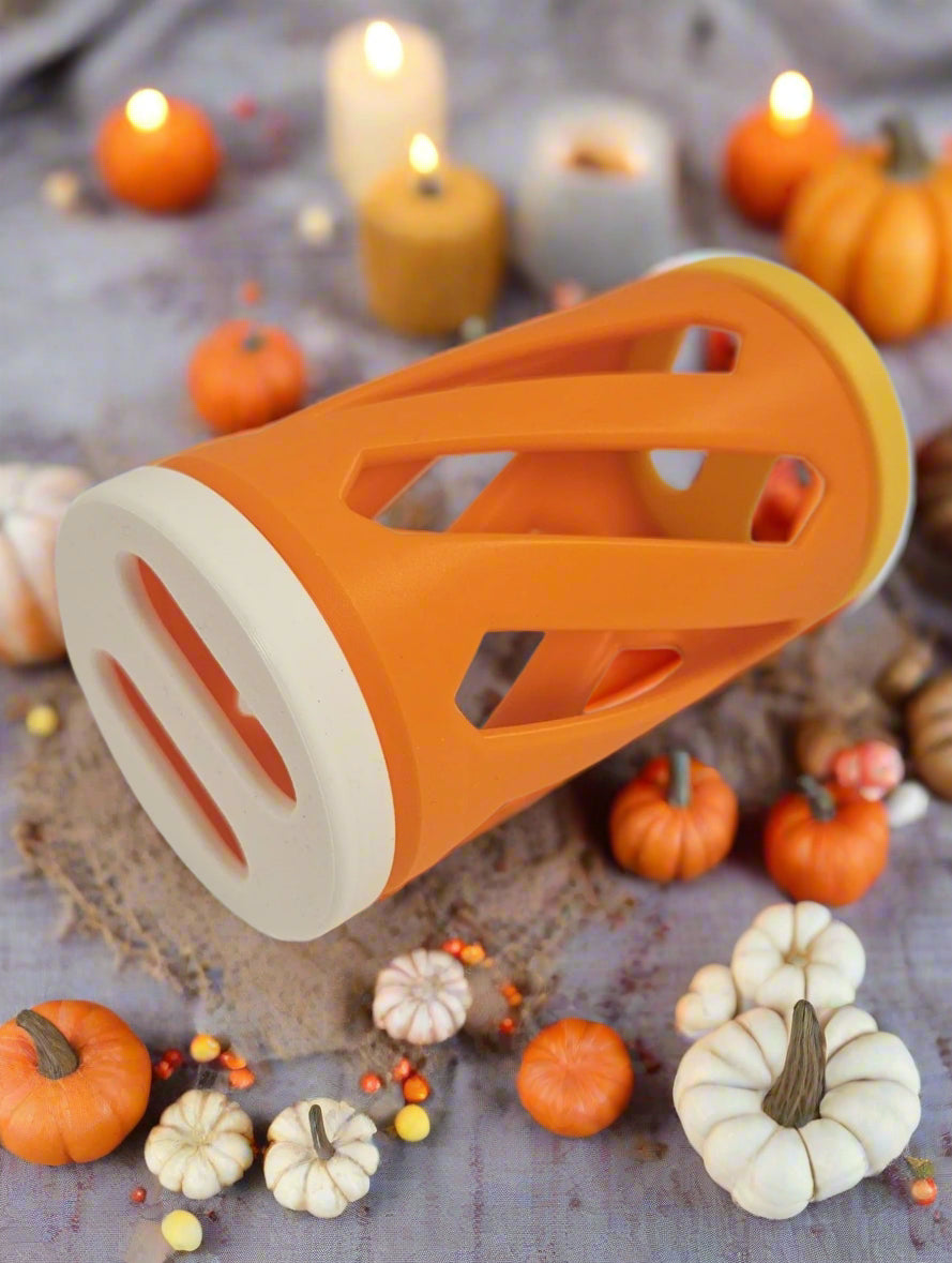 White, yellow and orange rabbit hay roller toy against an autumn background
