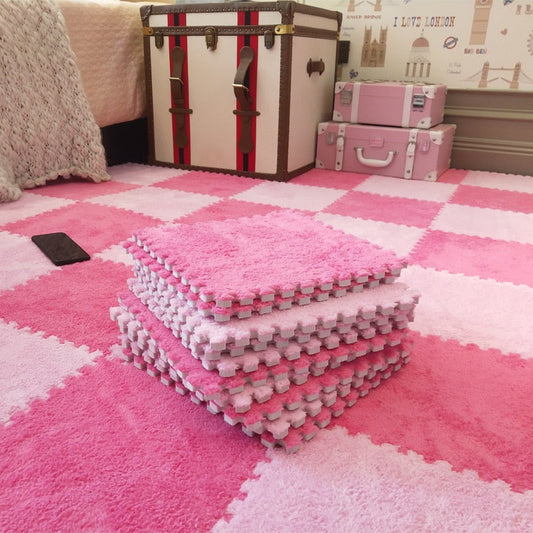 Pink and white foam puzzle mats on a checkered floor with storage boxes in the background.