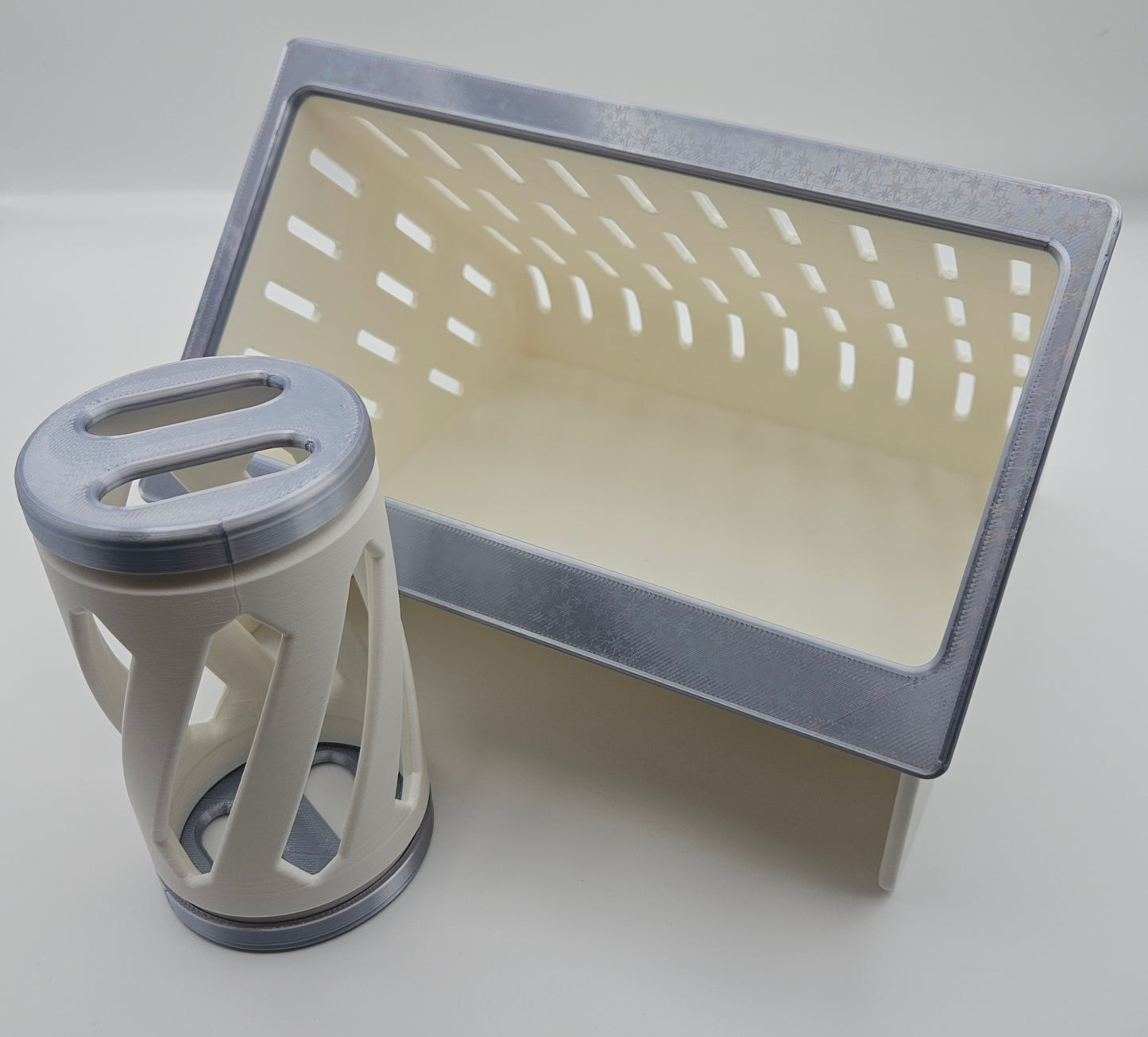 a silve rnad white hay roller toy and hay feeder for rabbits